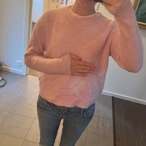 Ljusrosa stickad tröja Selected Femme - Mysig ljusrosa stickad tröja från Selected Femme med rund hals och långa ärmar. Tröjan har en loose passform och är jätte mjuk, säljer för att den inte kommer till användning 