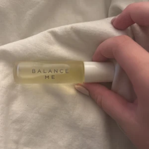 Balance Me parfym roll-on 10ml - Parfym från Balance Me i en smidig 10ml glasflaska med vit plastlock och roll-on applikator. Flaskan är transparent med ljusgul vätska och minimalistisk text. Vegansk och tillverkad i Storbritannien. Perfekt att ha med i väskan.