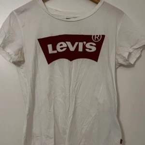 Levi’s Tshirt - Vit tshirt från Levi’s med rött tryck på framsidan. Storlek S. Knappt använd och i bra skick💕 Texten på insidan i nacken är lite sliten (3e bilden) 