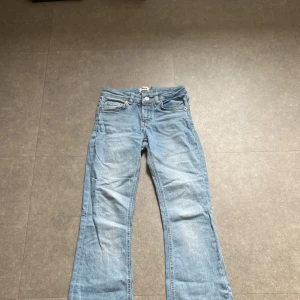 Bootcut jeans i ljusblå denim från 157 - Snygga bootcut jeans från 157 i ljusblå denim. Modellen är midde waist med klassiska fem fickor och tydliga sömmar. Jeansen har en bredare benvidd nedtill. Litet hål längst ner på vänstra bakbenet. Använda mycket men fortfarande bra skick💕