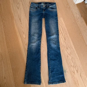 Blå bootcut jeans från LTB Valerie💓 - Snygga blå jeans från LTB Valerie med klassisk bootcut passform. Byxorna är lågmidjade med lite detaljer på bakfickorna!! De är i fint skick förutom små slitningar längst ner på byxbenen, man tänker inte på det😋 Midjemåttet rakt över är 36 cm och innebenslängden är ca 80 cm🥰🥰 Skriv gärna vid andra frågor, tryck annars gärna på köp nu😉🥰