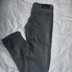 Grå jeans från Acne Studios, strl 29/30 - Snygga grå jeans från Acne Studios i klassisk femficksmodell. Jeansen har dragkedja, raka ben och normal passform. Materialet är mjukt denim i bomull och de har diskreta detaljer i silver vid knappar och dragkedja. Perfekt för dig som gillar stilrena och tidlösa jeans.