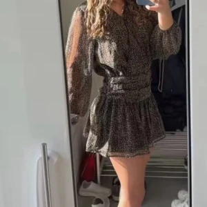 Leopardmönstrad kort klänning med volang - Säljer en klänning med leopardmönster i svart och brun. Klänningen har långärmade, lätt transparenta ärmar, v-ringad hals och volang nedtill. Midjan är markerad med snygga rynkade detaljer. Perfekt för dig som gillar att vara lite extra fin! Storlek 158/164  men passar bra på mig som vanligtvis brukar ha xs och är 164cm lång