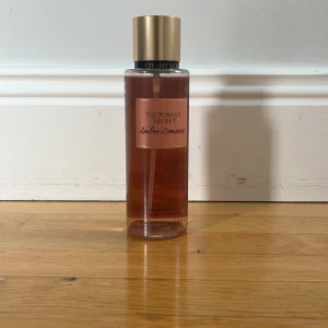 Victoria's Secret Amber Romance mist - Amber Romance från Victoria's Secret är en body mist i en genomskinlig plastflaska med guldigt lock. Doften har inslag av djup amber och sötma, perfekt för dig som gillar varma och sensuella toner. Flaskan rymmer 250 ml och har en snygg roséguldig etikett.