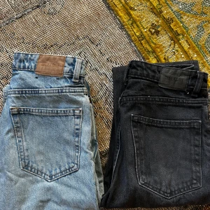 Weekday jeans blå & svarta straight - Två par jeans från Weekday, ena i ljusblå tvätt och andra i svart. Blå modellen heter Voyage. Storlek 24/28. Säljes för 250:- för båda