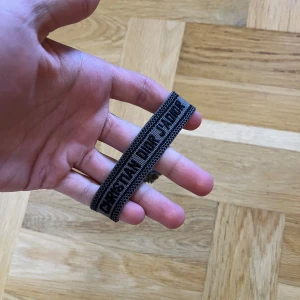 Christian Dior J'Adior armband i brun/svart - Snyggt vävt armband från Christian Dior. Har inte någon användning för det och har ändrat stil så passar inte längre. OBS: Kom med bud så kan vi förhandla!