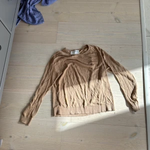 Beige stickad tröja från Selected Femme - Snygg beige stickad tröja från Selected Femme i storlek P/S. Tröjan har rund halsringning, långa ärmar och ribbade muddar vid ärmslut och nederkant. Perfekt för lager-på-lager och chill stil under höst och vinter.