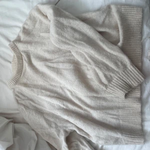 Beige stickad tröja från Bik Bok - Mysig beige stickad tröja från Bik Bok i storlek M. Tröjan har rund hals och ribbade muddar vid ärmslut och nederkant. Perfekt för lager-på-lager och chill dagar. Materialet är mjukt och ger en skön känsla, passar dig som gillar enkel och clean stil.