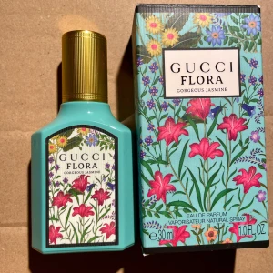 *NY*Gucci Flora Gorgeous Jasmine EdP 30ml - Gucci Flora Gorgeous Jasmine Eau de Parfum 30ml med turkos flaska och guldfärgat lock. Doften har noter av jasmin, magnolia och mandarin. Flaskan och kartongen har blommigt mönster i rosa, gult och grönt. Perfekt för dig som gillar fräscha och blommiga parfymer.