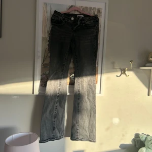 Grå bootcut jeans från Perfect Jeans - Snygga grå jeans från Perfect Jeans i bootcut-modell. Jeansen har klassisk femficksdesign, silverfärgad knapp och dragkedja. Materialet är mjukt denim som ger en skön känsla och cool tvättad look. Låg midja 