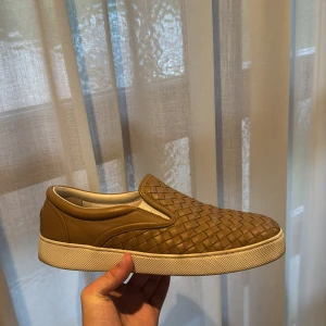 Bottega Veneta Slip on Sneakers  - Säljer ju mina Bottega Veneta sneakers i läder, de är bruna och går att kombinera med massvis av kulörer och outfits. Skorna är i toppen skick och är riktigt bekväma.