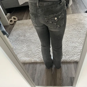 Grå bootcut jeans med detaljer från Gina tricot - Snygga grå jeans med bootcut passform och snygga detaljer på bakfickorna. Jeansen är lowwaist men lite mer åt midwaist hållet.  De är från Gina tricot och är i strl 164 