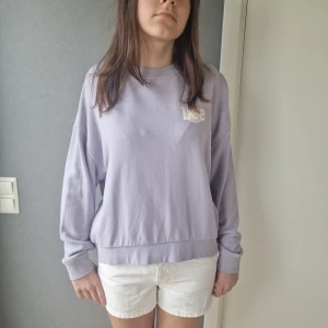 Ljuslila sweatshirt från Lee - Superfin ljuslila sweatshirt från Lee med tryckt logga på bröstet. Tröjan har en loose passform, rund halsringning och långa ärmar med muddar. Perfekt för dig som gillar en avslappnad och trendig stil.