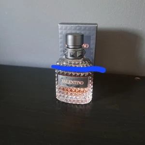 Valentino Uomo Born In Roma Coral Fantasy - Exklusiv parfym från Valentino, Uomo Born In Roma Coral Fantasy. Flaskan är 50 ml och har en lyxig, nitar-inspirerad design i genomskinligt glas med svagt rosa-orange vätska och svart mattsvart kork. Kommer med originalkartong. Använd ett fåtal gånger så det är mellan 45-50 ml kvar😁