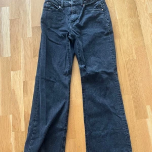 Low waist jeans Gina Tricot  - Snygga svarta jeans från Perfect Jeans i modell med breda ben och klassisk femficksdesign. Jeansen har hög midja och raka, vida ben för en trendig och avslappnad look. Perfekta att matcha med sneakers eller boots.