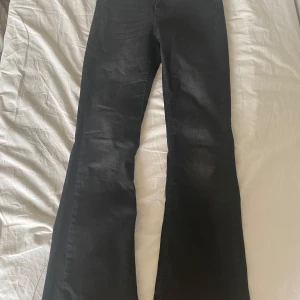 Svarta bootcut jeans från ONLY - Säljer ett par svarta bootcut jeans från ONLY i storlek S/30. Jeansen har klassisk femficksdesign och är tillverkade i ett mjukt bomullsmaterial med lite stretch. Snygg passform med utsvängda ben som ger en trendig siluett.