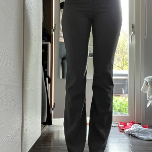 Grå kostymbyxor med hög midja - Snygga grå kostymbyxor med låg midja och rak passform. Byxorna har diskret dragkedja och knapp framtill. Perfekta för en stilren look och passar till många olika outfits.