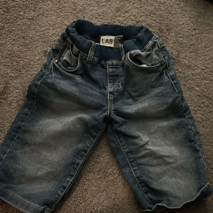 Mörkblå jeansshorts från LAB - Snygga mörkblå jeansshorts med resår i midjan och klassiska fickor fram och bak. 