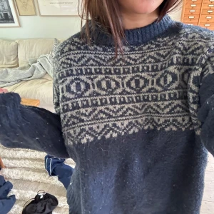 Mörkblå stickad tröja med mönster från CRW - Mysig mörkblå stickad tröja från CRW med ljusgrått nordiskt mönster upptill. Tröjan har lång ärm och ribbad halsringning. Lite nopprig 