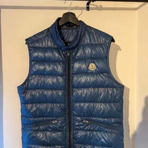 Moncler gui väst - Moncler gui väst mörkblå. Storlek 2 passar S/M(170-180cm). Finns väldigt små hål, läcker inga fjädrar. Utbytt zipper och dragkedja. Kan utlevereras runt Göteborg eller fraktas via PostNord.