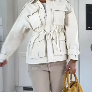 Vit kappa med knytning - En superfin vit jacka perfekt till våren!! Den har några fläckar men dem syns inte alls, däremot värt att notera!