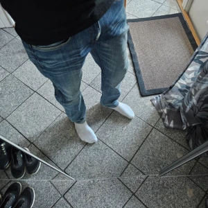 Blå jeans från Dobber W31 - Klassiska blå jeans från Dobber med raka ben och fem fickor. Jeansen har en normal passform och är tillverkade i denim med snygga slitningar framtill och bak. Storlek W31