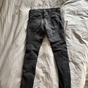 Svarta slim jeans från G-Star RAW  - Svarta jeans från G-Star RAW, modell 3301, med slim passform. Klassisk femficksdesign, silverfärgade knappar och diskreta sömmar. Jeansen har en rak siluett och är tillverkade i ett stretchigt denimtyg för extra komfort.