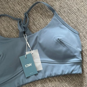 Blå linnetopp från ICANIWILL - Supersnygg blå linnetopp från ICANIWILL med smala axelband och brottarrygg. Perfekt för träning eller chill dagar. Topp i mjukt och stretchigt material som sitter skönt på kroppen. Enkel och stilren design med diskret logga framtill.