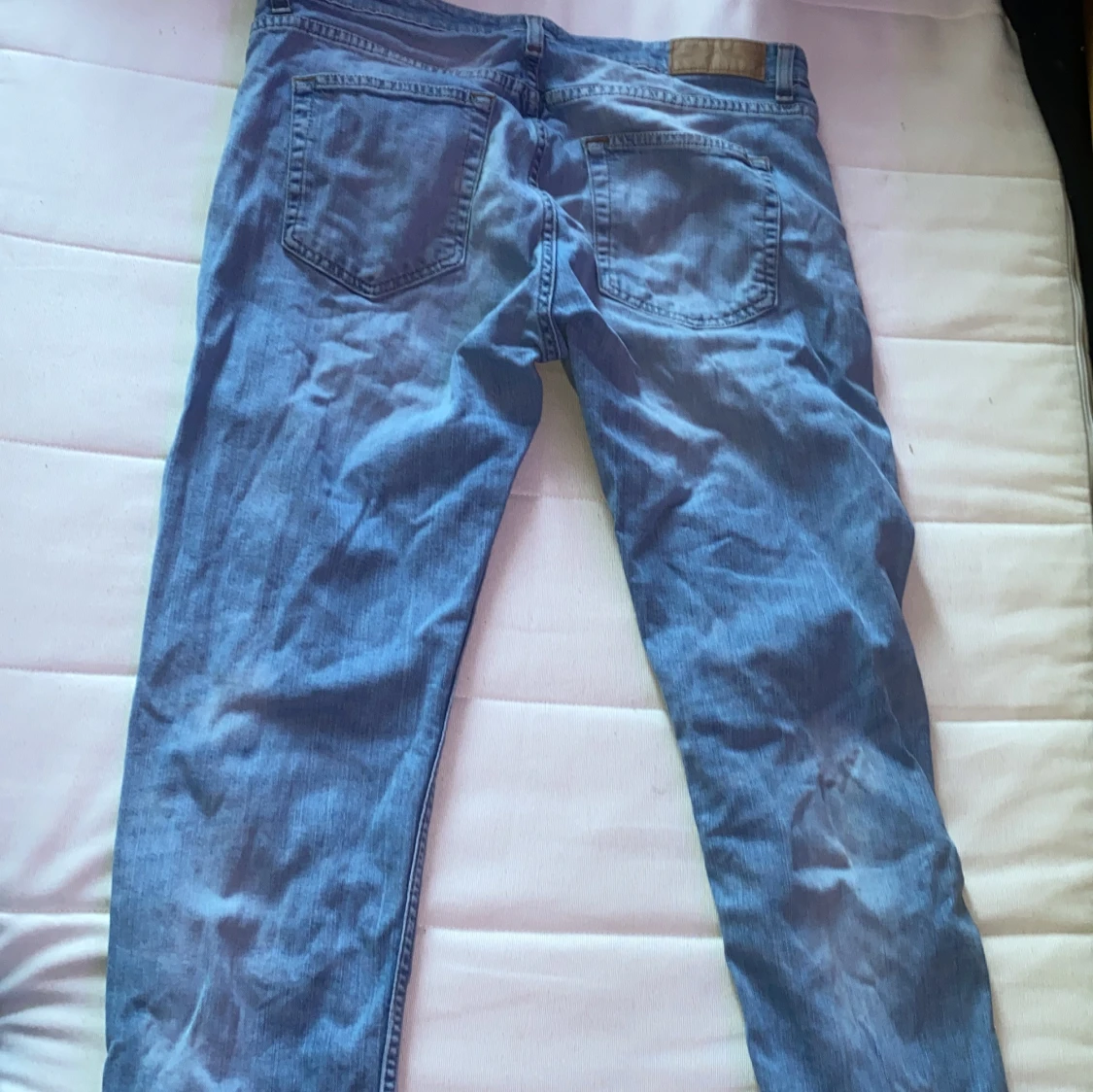 Blå jeans med slitning på benet - 1