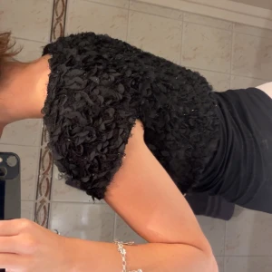 Svart bolerotopp - Supersnygg svart bolerotopp med korta ärmar och blommor samt lätt glittri