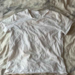 Vit t-shirt från 157 i bomull xs - En klassisk vit t-shirt från 157 i storlek XS. Gjord i mjuk 100% bomull med rund hals och korta ärmar. Perfekt basic-plagg med enkel och clean look, passar till allt och är superbekväm. Snygg att styla med jeans eller shorts.