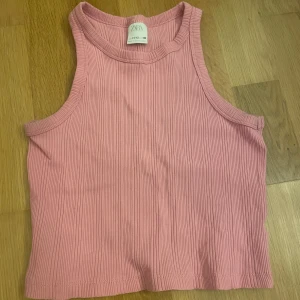 Rosa ribbad linnetopp - Säljer en söt rosa ribbad linnetopp från Zara. Toppen är ärmlös med rund halsringning och croppad passform. Perfekt för varma dagar och enkel att matcha med jeans eller kjol. Är i storlek 152 men passar mig som har XS superbra. Knappt använd ock supersnygg!!!!😍😍😍💞💞💞