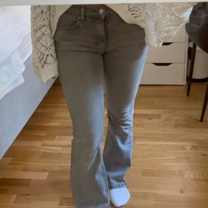 Grå bootcut jeans från Perfect Jeans - Snygga grå jeans från Perfect Jeans Ginatricot med bootcut passform och låg midja. Jeansen är i mjuk denim med klassiska fickor och bälteshällor.Passar för dig som är runt 155-160 cm lång, då byxorna är petite. 🩶