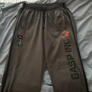 GASP grå träningsbyxor L - Säljer ett par grå träningsbyxor från GASP. Storlek large och är i mycket bra skick. Använt endast 2 gånger! Materialet är syntetiskt och andas, perfekt för gym eller chill.