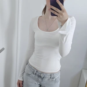 Vit långärmad topp från Gina Tricot - Säljer en vit långärmad topp från Gina Tricot med rundad halsringning. Den är använd ca 5 gånger men är fortfarande så god som ny! Jag säljer den eftersom att jag inte använder den, jag köpte den för 249 kr från början.