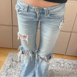 Ljusblå slitna bootcut jeans - Säljer mina favorit ljusblå bootcut jeans med rejält slitna och trasiga detaljer vid knän och benslut. Jeansen har låg midja och klassisk femficksdesign.  Passar mig perfekt som är 162cm och har w24 i jeans💞