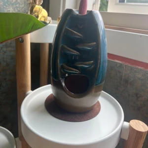 Rökelsehållare - En rökelsehållare och en påse med färgade rökelsekoner.