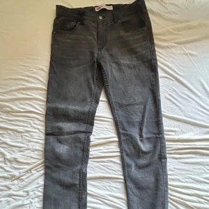 Grå Levi's jeans straight fit - Snygga grå jeans från Levi's 512 Slim taper med klassisk femficksdesign och raka ben. Jeansen har en mörkgrå ton, Levi's logga på bakfickan och robust knappstängning fram. Perfekt för dig som gillar en enkel och stilren look med streetvibe. Nypris ≈ 600. De är ganska använda som man ser på bilderna högra bag fickan har et litet hål men syns knappt och Levis loggan där bag har gått av lite och lite där fram. Storlek 170cm 16A