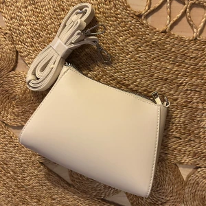 Liten väska - Liten vit handväska. Helt oanvänd. Följde med en större väska som jag använder istället. Från Zalando märket Even & Odd. Säljer likadan i brun!🌺 Allt ska bort, med med prisförslag!