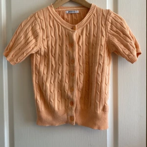 Kabelstickad kofta - Aprikosfärgad Kabelstickad kofta från Gina Tricot i S