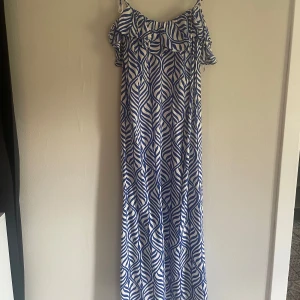 Blåvit långklänning med volang från H&M - Säljer en blåvit långklänning från H&M i storlek XS