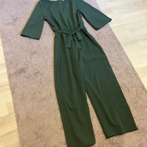 Grön fin byxdress - Somrig mysig byxdress med rund halsringning och trekvartsärmar. Dressen har ett knytband i midjan för en gullig look. 