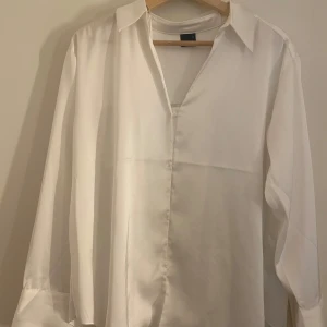 Vit satin skjorta  - En super fin vit långärmad skjorta i satin material med v-ringning samt krage! Endast använd en gång men har inga tecken på användning. PS. Kan upplevas stor i storleken!! Säljs för 150kr!💕