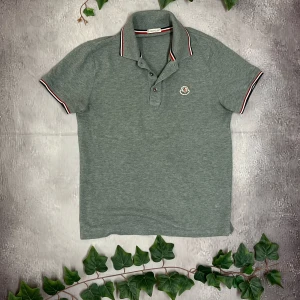 Moncler Manglia Polo Manica Corta - 🎨 Färg:Lite mörkare grå 📏 Storlek: S 📐 Mått: Fråga ifall det önskas! ♻️ Skick: 9/10 🧵 Material: 100% bomull   ‼️Skickas dagen efter köpet genomförs‼️