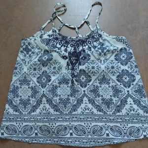 Mönstrat Linne - Ett linne mönstrat i vitt/mörkblått med broderier på bröstet och snygg rygg. Storlek 160 men sitter som S. Fint använt skick utan defekter. Har älskat det här plagget men nu har det tyvärr blivit lite för litet.
