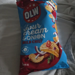 Olw premium går att förhandla - Bilderna visar en påse OLW Sour Cream & Onion Mild Chili chips, 275g. Detta är en snacksprodukt och ingen bok. Ingen information om boktitel, författare eller innehåll kan identifieras från bilderna.