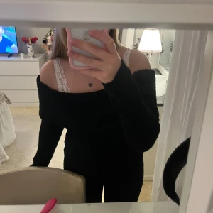 Svart offshoulder stickad tröja - Snygg svart stickad tröja med offshoulder-modell och långa ärmar. Tröjan har en ribbad struktur och sitter lite loose över axlarna, perfekt för en trendig och avslappnad look. Passar dig som gillar att sticka ut med en enkel men stilren vibe. Från hm.