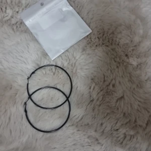 Stora svarta hoops örhängen - Ett par stora stilrena svarta hoops / creoler örhängen, ca 8 cm i diameter. 316L kirurgiskt stål.  Helt nya och oanvända,  endast uttagna för att ta bilder.