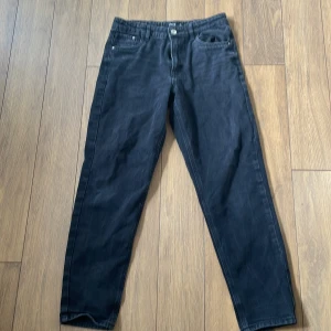 Svarta jeansbyxor från LMTD XS/S - Svarta jeansbyxor från LMTD i storlek XS/S. Klassisk femficksmodell med raka ben och normal passform. Byxorna har knapp och dragkedja framtill och är tillverkade i ett mjukt bomullsmaterial med lite stretch.