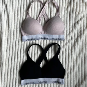 2 Calvin Klein bralettes - Använt skick med slitna band (främst sidorna)  samt ludd och obehandlad fläck på den rosa. Ena saknar etikett men båda är i storlek M bara att den svartas band undrr bysten är mer slitna än den rosa